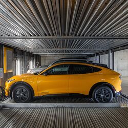 Das Bild zeigt ein Auto auf einer Plattform innerhalb eines automatisierten Parksystems in einer modernen Tiefgarage.
