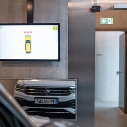 Auto steht vor einem Spiegel und Monitor