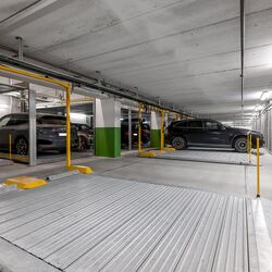 Mehrere Autos stehen auf der Parkplatte in einer Tiefgarage
