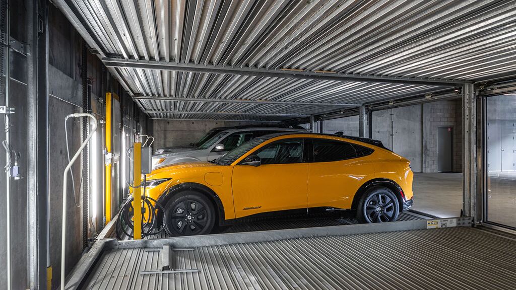 Das Bild zeigt ein Auto auf einer Plattform innerhalb eines automatisierten Parksystems in einer modernen Tiefgarage.