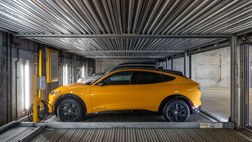 Das Bild zeigt ein Auto auf einer Plattform innerhalb eines automatisierten Parksystems in einer modernen Tiefgarage.