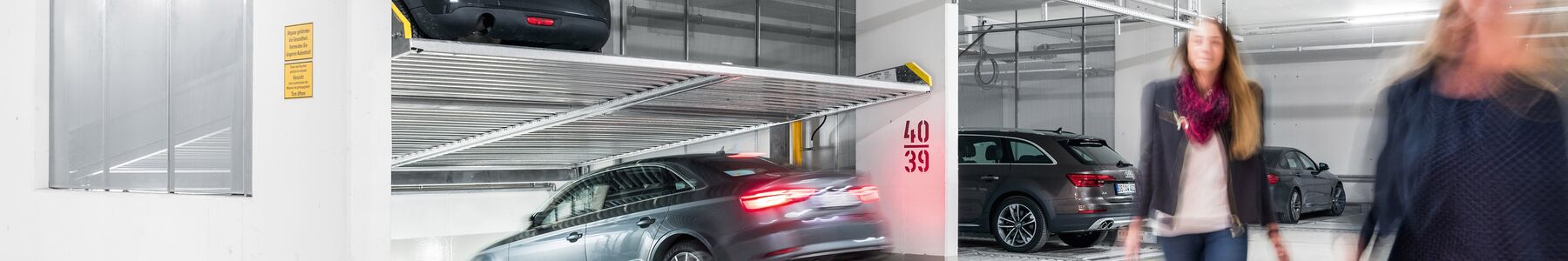 Photo of an underground car park with cars stacked on top of one another in a parking system