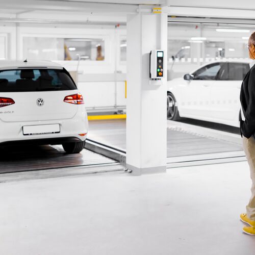 Mann steht vor einem Parksystem mit Autos