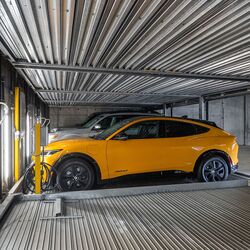 Das Bild zeigt ein Auto auf einer Plattform innerhalb eines automatisierten Parksystems in einer modernen Tiefgarage.